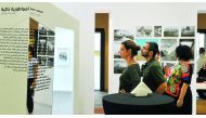 Art enthusiasts read the text on the exhibition at the entrance of 
