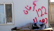 A displaced man sleeps on the table at a school used as a shelter in Bawiza, north of Mosul, Iraq November 13, 2016. REUTERS/Ari Jalal