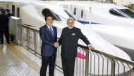 Indian Prime Minister Narendra Modi (R) and Japan's Prime Minister Shinzo Abe pose in front of a Shinkansen bullet train before heading for Hyogo prefecture at Tokyo Station, Japan November 12, 2016, in this photo taken by Kyodo. Kyodo/via REUTERS 