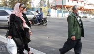 Iranians wearing face masks walk in Tehran as the first of the winter's heavy pollution hit the Iranian capital on November 14, 2016. A blanket of choking brown-white smog descended on the city, blocking out the view of the mountains that line its norther