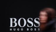 A woman walks past Hugo Boss store logo on a shopping center at the outlet village Belaya Dacha outside Moscow, Russia, April 23, 2016. REUTERS/Grigory Dukor