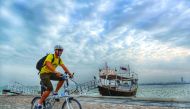 A cyclist pedals along the Corniche under cloudy skies in Doha yesterday. 
Pic: Salim Matramkot / The Peninsula