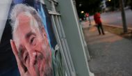 A picture of Fidel Castro as a local is seen on a wall as a resident walks along an empty street, following the announcement of the death of Cuban revolutionary leader, in Havana, Cuba November 27, 2016. REUTERS/Carlos Barria 