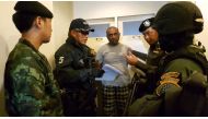 This handout received by the Royal Thai Police and taken on December 3, 2016 shows Abdul Rehman (C), a Pakistani national who was arrested in Bangkok on December 2 on suspicion of starting a devastating 2012 factory fire in Karachi killing 259 people, at 