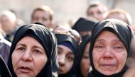 Women react as they wait outside a government military police centre to visit their relatives, who were evacuated from the eastern districts of Aleppo and are being prepared to begin their military service, in Aleppo, Syria December 11, 2016. REUTERS/Omar