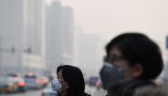 Pedestrians wear masks on a polluted day in Beijing on December 12, 2016. Authorities issued a yellow alert on December 11 for pollution in areas of northern China, including Beijing. / AFP / GREG BAKER

