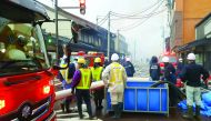Residents look at firefighters at the scene of a blaze,  near JR Itoigawa Station, Niigata Prefecture, in Japan, yesterday. 