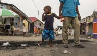 (FILES) This file photo taken on December 20, 2016 shows a child staring at the marks of burnt tyres following a protest in the Lingwala neighborhood in Kinshasa. AFP / Eduardo Soteras
