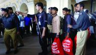 Fishermen from India are guided by policemen after they were released from a prison, at Cantonment railway station in Karachi, yesterday.