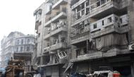 A tractor removes rubble as the Syrian government starts to clean up areas formerly held by opposition forces in the northern city of Aleppo on December 27, 2016, in the Shaar district.  AFP / George OURFALIAN