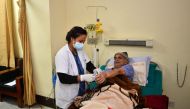 In this photograph taken on December 7, 2016, Nepalese orthopaedic surgeon Govinda KC has a sample taken by a medical attendant as he lies in a hospital bed in Kathmandu. Govinda KC spent 22 days lying on a gurney in a hospital in Nepal's capital Kathmand