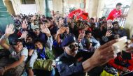 Fishermen from India who were held captive for crossing territorial waters wave for a selfie by a policeman after their release, at Cantonment railway station in Karachi, yesterday.