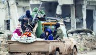 Rebel fighters ride on a pick-up truck in the northern Syrian rebel-held town of Al Rai, yesterday.