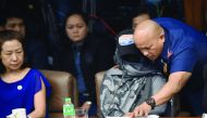Philippine Police Chief Ronald Dela Rosa shows photos to Marissa Morquicho, the househelp of Jee, as they appear at a Senate hearing into Jee's death, in Manila, yesterday.
