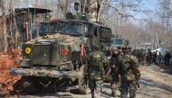 Indian security personnel walk through the scene of a firefight in Frisal village in Kulgam, some 70 kms south of Srinagar, on February 12, 2017. AFP
