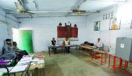 Polling officers wait for voters at a polling station during the state assembly election, in Lucknow, yesterday.