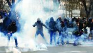 Clouds of tear gas surround youth as they face off with French police during a demonstration against police brutality in Paris, yesterday.