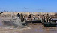 International coalition forces and Iraqi soldiers instal a floating bridge at the Taji camp, north of Baghdad, during a training session ahead of installing replacement bridges in Mosul, on March 6, 2017 (AFP Photo/Sabah Arar).