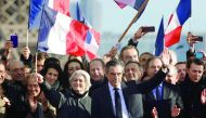 A file photo of French presidential candidate Francois Fillon (centre-right) gesturing at supporters next to his wife Penelope Fillon (centre-left) waving a French flag, during a rally in Paris.