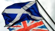 (FILES) A file picture taken on August 17, 2014, shows Scotland's Saltire flag (Top) and Britain's Union flag in Gretna in Scotland, ahead of the referendum on Scotland's independence.  AFP / ANDY BUCHANAN