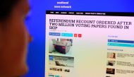 A journalist poses reading a satirical fake news story on the Southend News Network website in London on March 31, 2017. AFP / DANIEL SORABJI 
