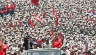 Handout picture released by the Venezuelan Presidency showing Venezuelan President Nicolas Maduro (C) saluting next to his wife Cilia Flores as they arrive for the celebrations for the seventh anniversary of the Bolivarian Militia in Caracas on April 17, 