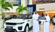 A QNB official handing the keys of Range Rover Evoque  to the winner. 