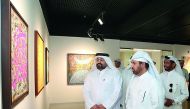 Visitors look at the artworks displayed at the exhibition.