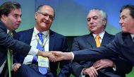 President of the Brazilian lower house Rodrigo Maia (L) shakes hands with president of the Brazilian senate Eunicio Oliveira (R) next to Brazilian President Michel Temer (2-R) and Sao Paulo's governor Geraldo Alckmin, during an Investment Forum in Sao Pau