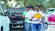 Ooredoo volunteers with Ramadan gift packs walk amidst vehicles on the Corniche. 