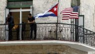 Two men stand on a balcony next to the Cuban and USA National Flags in Havana Cuba, March 17, 2016 (EPA / ERNESTO MASTRASCUSA) 