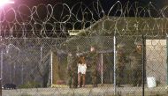 Marines at Camp X-Ray at the Naval Base at Guantanamo Bay, Cuba escort a newly arriving detainee into a processing tent after being showered in this February 7, 2002 file photo. REUTERS/Marc Serota