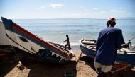 A fisherman works next to a boat in Cap-Haitien, Haiti, on September 6, 2017, 240kms north of Port-au-Prince. Some people in Cap-Haitien still do not have information on the arrival of Hurricane Irma and many others do not know what to do or where to go t