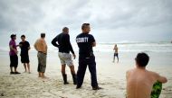 Tourists and a security agent are seen on a beach a day after the passage of Hurricane Irma in Varadero, Cuba, September 10, 2017. REUTERS/Alexandre Meneghini
