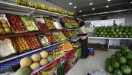 A picture taken on October 2, 2017 shows a fruit seller laying out bananas and organising produce at a shop in the Sudanese capital's twin city of Omdurman.   AFP / ASHRAF SHAZLY
