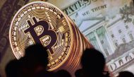 An image of Bitcoin and US currencies displayed on a screen as delegates listen to a panel of speakers during the Interpol World Congress in Singapore on July 04, 2017 (AFP / Roslan Rahma) 
