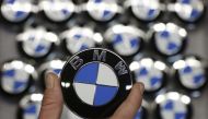 An employee holds a BMW logo on the production line of the BMW C evolution electric maxi-scooter at the BMW Berlin motorcycle plant, February 23, 2015 (Reuters/Fabrizio Bensch) 