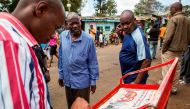 Residents of Nairobi's Kibera slum, a stronghold of Kenyan opposition leader, follow up presidential election coverage in the newspaper while waiting official results.  AFP / Patrick Meinhardt
