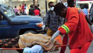 Somalis rescue workers carry the body of a victim at the scene of a blast on October 29, 2017, a day after two car bombs exploded in Mogadishu. AFP / Mohamed Abdiwahab
