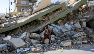 (file photo) A man sits on a concrete in front the collapsed building at Derbendihan district of Sulaymaniyah, in Iraq on November 13, 2017 following the 7.3 magnitude earthquake that hit the Iraq and Iran.  Yunus Kele? - AA 
