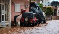 A man helps evacuate a woman from a flooded street in Mandra, northwest of Athens, on November 16, 2017. AFP / Dimitris Lambropoulos