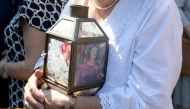 A woman holds a lantern with a picture of murdered journalist Daphne Caruana Galizia outside the law court in Valletta, Malta, on October 17, 2017 (AFP / Matthew Mirabelli) 