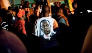 A supporter of Zimbabwe's incoming president Emmerson Mnangagwa wears a t-shirt with his portrait at Zimbabwe's ruling Zanu-PF party headquarters in Harare on November 22, 2017.  AFP / MARCO LONGARI

