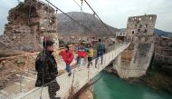 A file photo of Bosnian soldier standing on a hanging footbridge which replaced the old bridge of Mostar, southern Bosnia taken on December 17, 1995. / AFP / PASCAL GUYOT