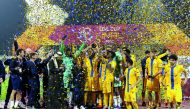 Al Gharafa players and officials celebrate after receiving the QSL Cup Trophy at Qatar SC Stadium yesterday. Pictures: Abdul Basit / The Peninsula