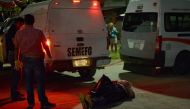 The corpse of a man found wrapped in black plastic tied by the hands and with signs of torture lies in the floor along the highway at the municipality of 