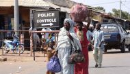A woman and children walk through the Senegalese-Gambia border town of Karangon,  May 10,  2016. AFP / seyllou