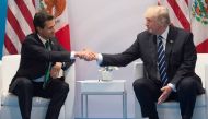 File photo of US President Donald Trump and Mexican President Enrique Pena Nieto shaking hands during a meeting on the sidelines of the G20 Summit in Hamburg, Germany, July 7, 2017.  / AFP / SAUL LOEB
 