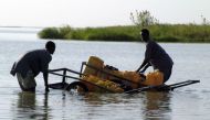 (FILE PHOTO) Chadian men collect water with plastic canisters loaded on a handcart in Lake Chad. Reuters