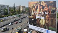 Indian commuters pass a poster advertising Facebook Live What You Love campaign in Bangalore on March 22, 2018. AFP/  Manjunath Kiran